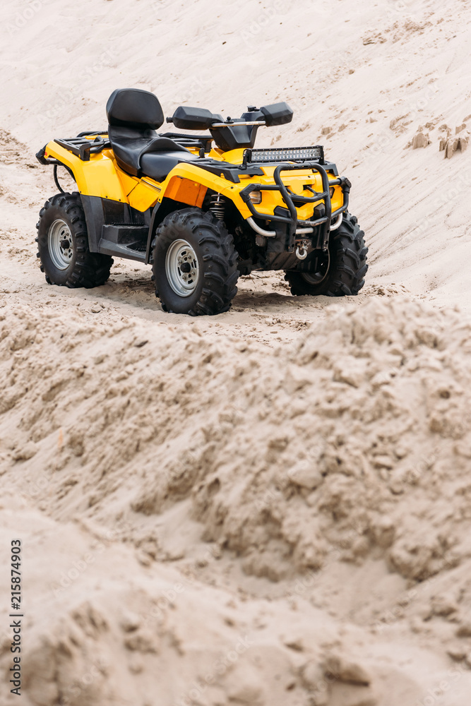 modern yellow all-terrain vehicle standing in desert