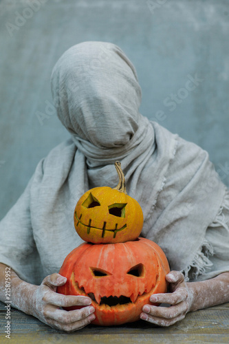 Scarecrow person and pumpkins photo