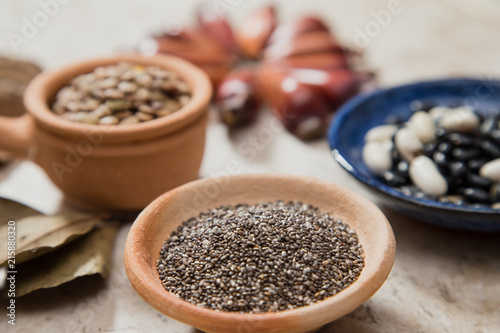 Composition with rustic pottery bowls of chia seeds, Lentils, and beans. Pinions and 'Castanha-do-Pará' nuts. Laurel Nobilis aromatic leafs