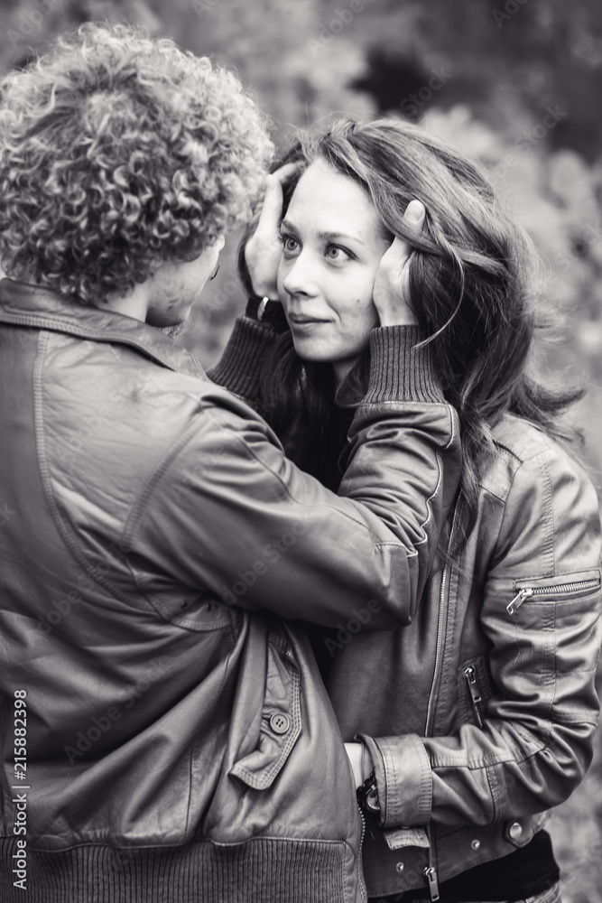 Curly-haired mustachioed man and brown-haired woman hugging in autumn. Curly-haired mustachioed man and brown-haired woman hugging in autumn.