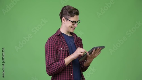 Young handsome teenage nerd boy using digital tablet