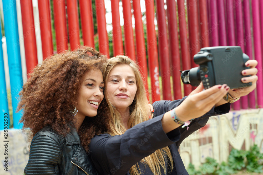 Pretty girls taking selfie via polaroid camera. Stock Photo | Adobe Stock