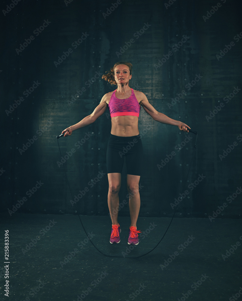 Young woman exercising with fitness jumping rope