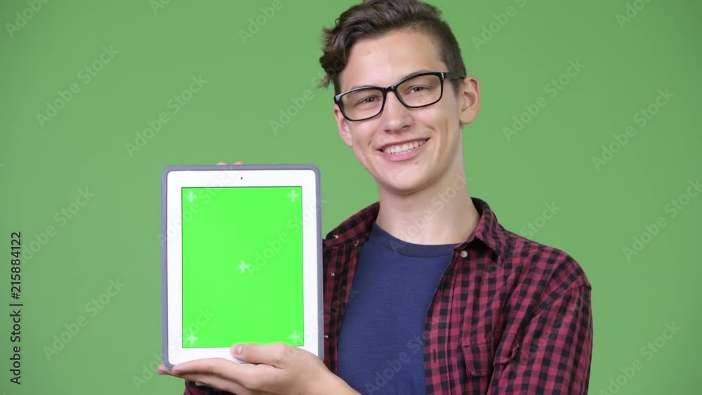 Young handsome teenage nerd boy showing digital tablet Young handsome teenage nerd boy showing digital tablet