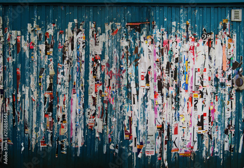 Grunge background with ripped posters on the wall of a metal container