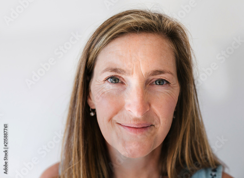 Healthy, mature woman looking at camera with plain background