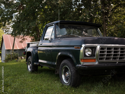 Passenger side of a vintage truck parked in rural countryside. photo