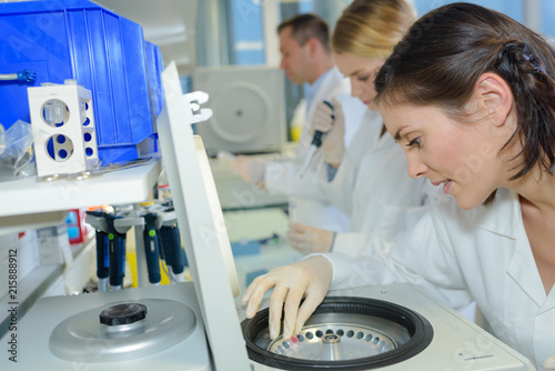 Woman operating laboratory centrifuge