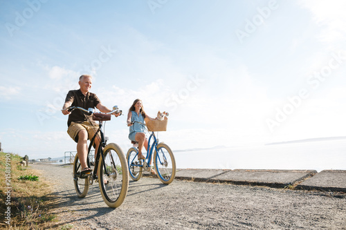 Healthy, active couple enjoying life riding cruiser bikes near o