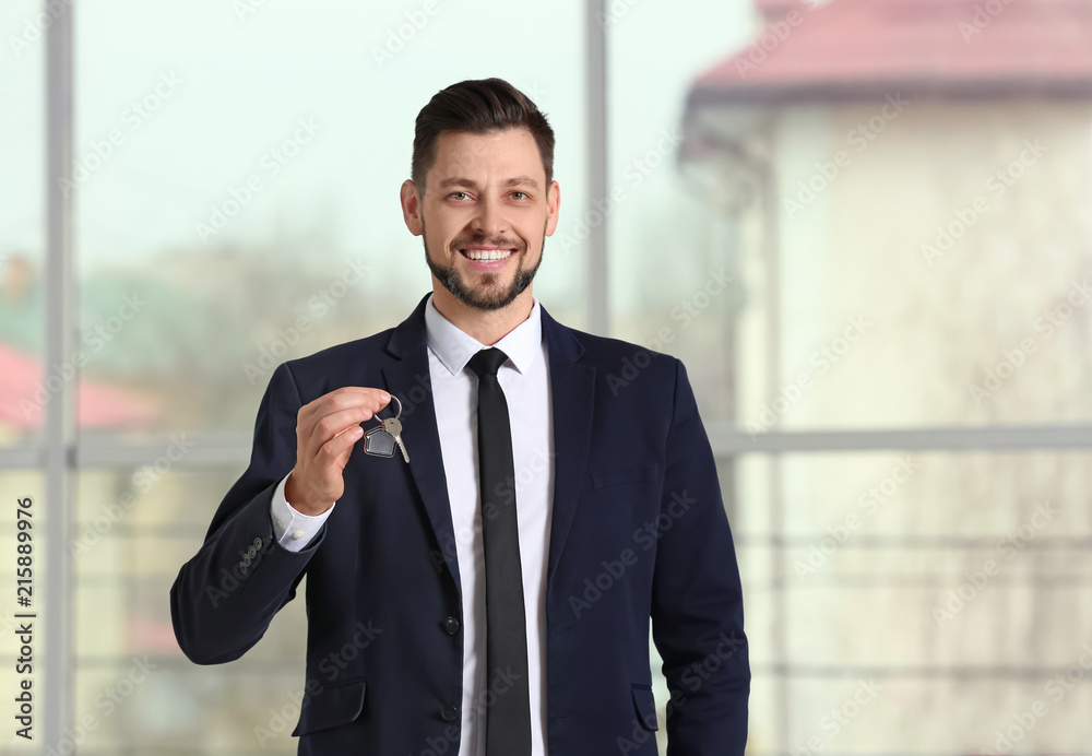 Real estate agent holding house key, indoors