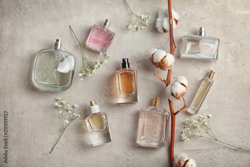 Beautiful composition with bottles of perfume on light background, flat lay