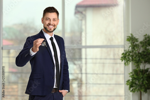 Real estate agent holding house key, indoors