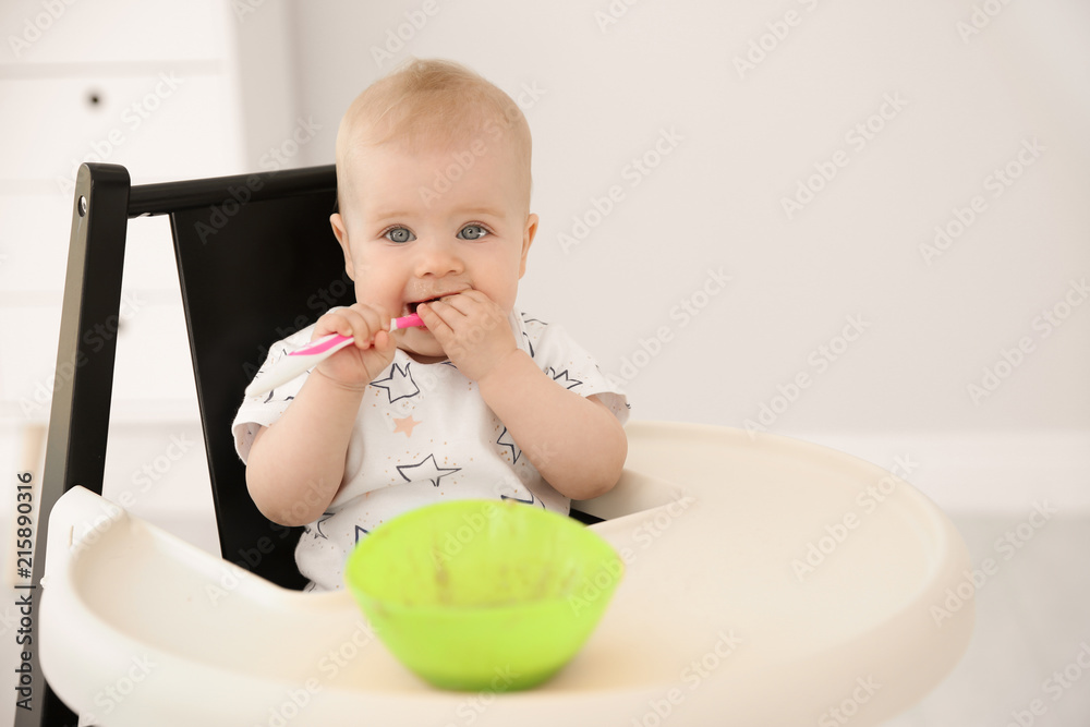 Cute little baby eating in high chair at home Cute little baby eating in high chair at home
