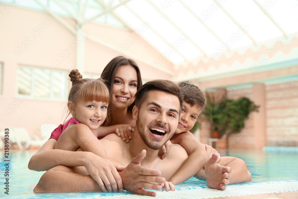 Fototapeta premium Happy family resting in indoor swimming pool