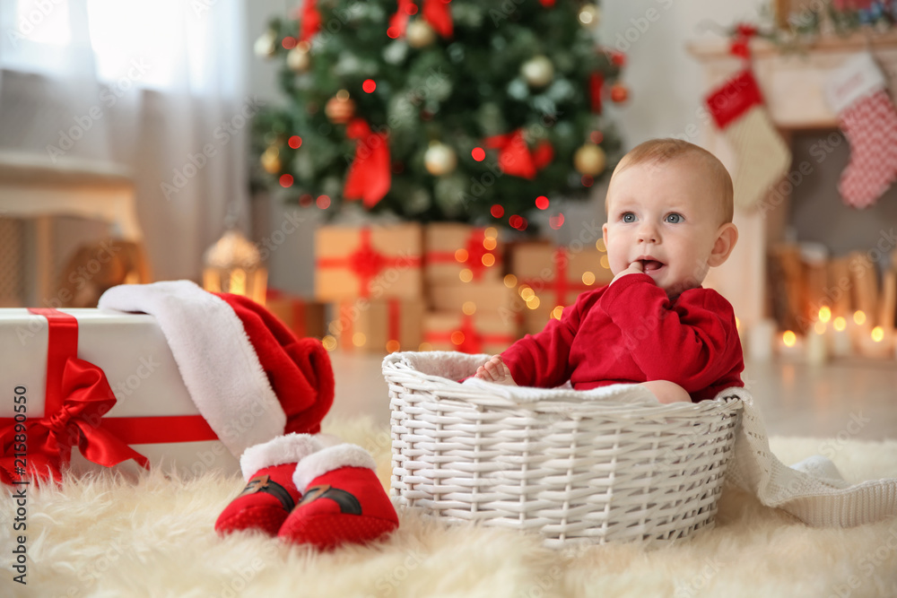 Cute baby sitting in basket at home. Christmas celebration Cute baby sitting in basket at home. Christmas celebration