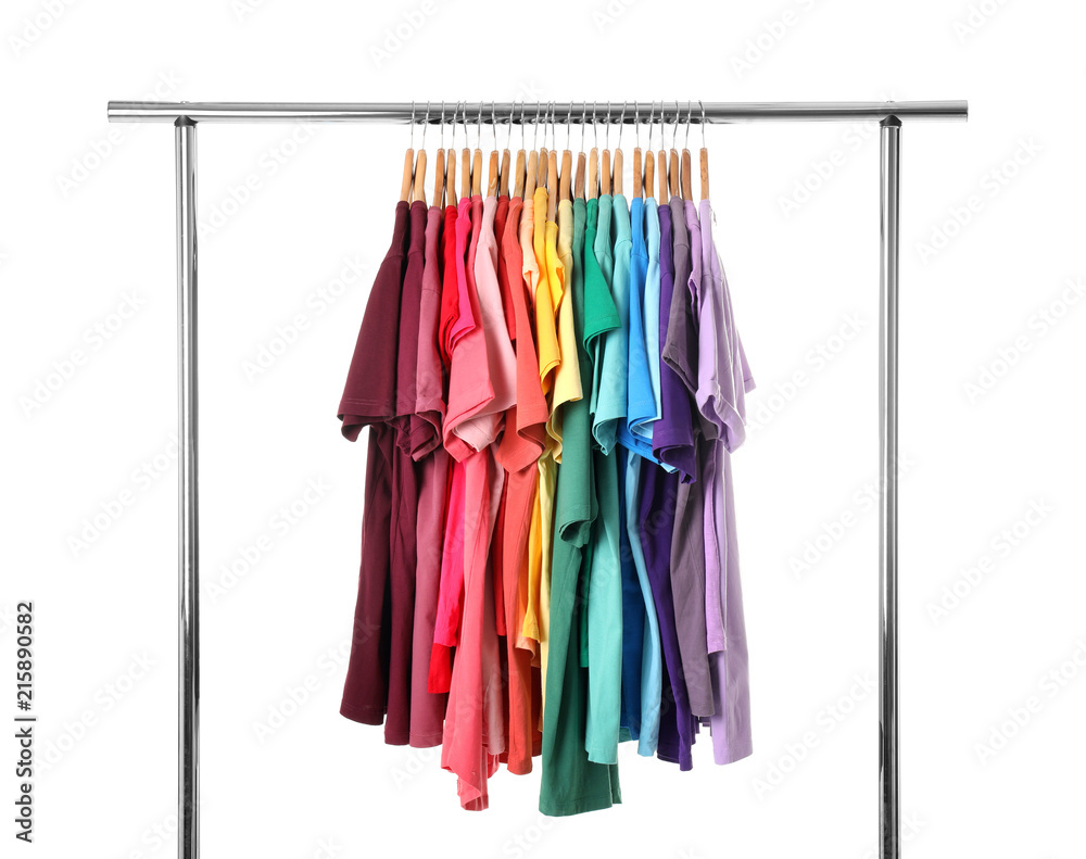 Rack with rainbow clothes on light background