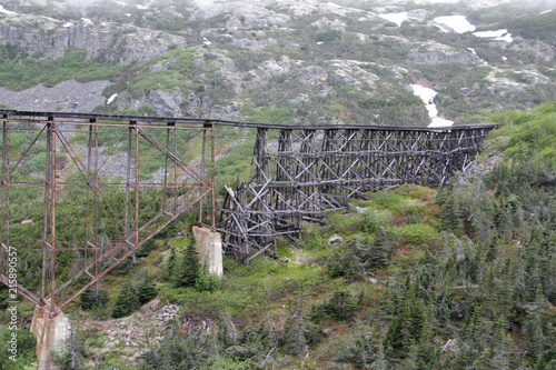 Old railroad bridge infront of snowy mountains photo