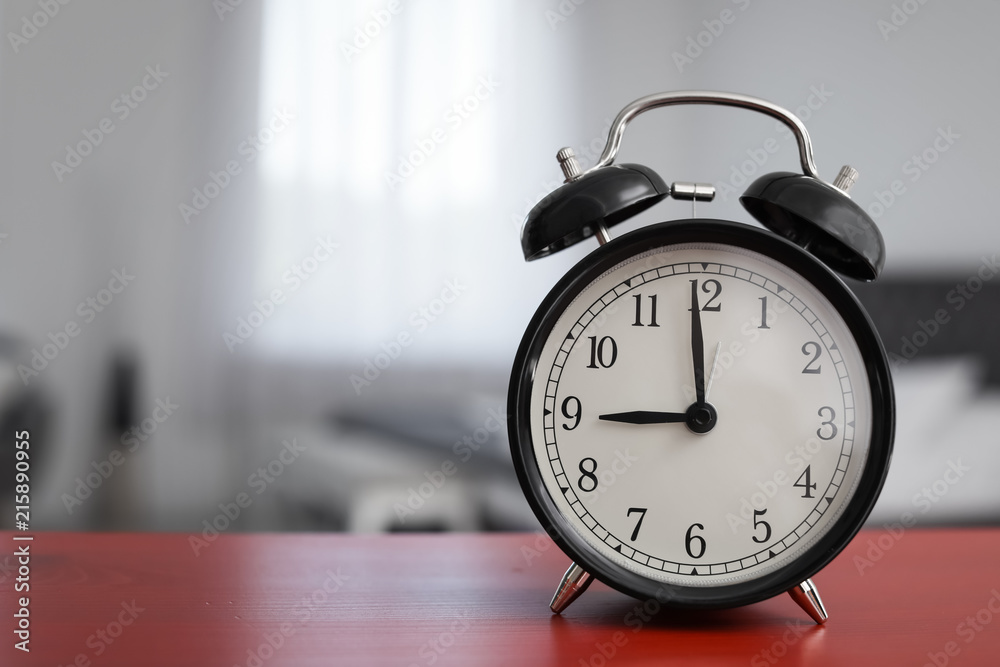 Alarm clock on table in bedroom. Time of day Alarm clock on table in bedroom. Time of day
