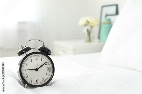 Alarm clock on bed. Time to wake up