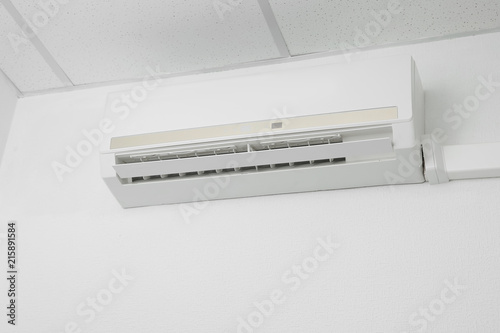 Modern air conditioner on white wall indoors © New Africa