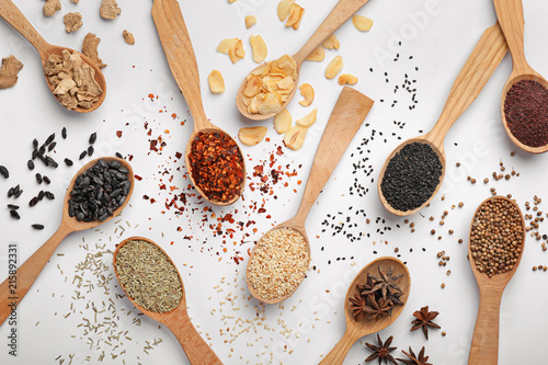 Fototapeta Naklejka Na Ścianę i Meble -  Composition with different aromatic spices in wooden spoons on white background