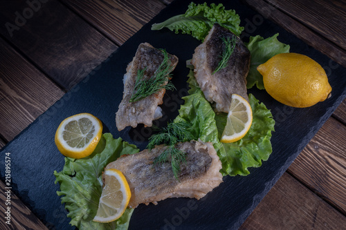 Fried fish with lemon and lettuce leaves