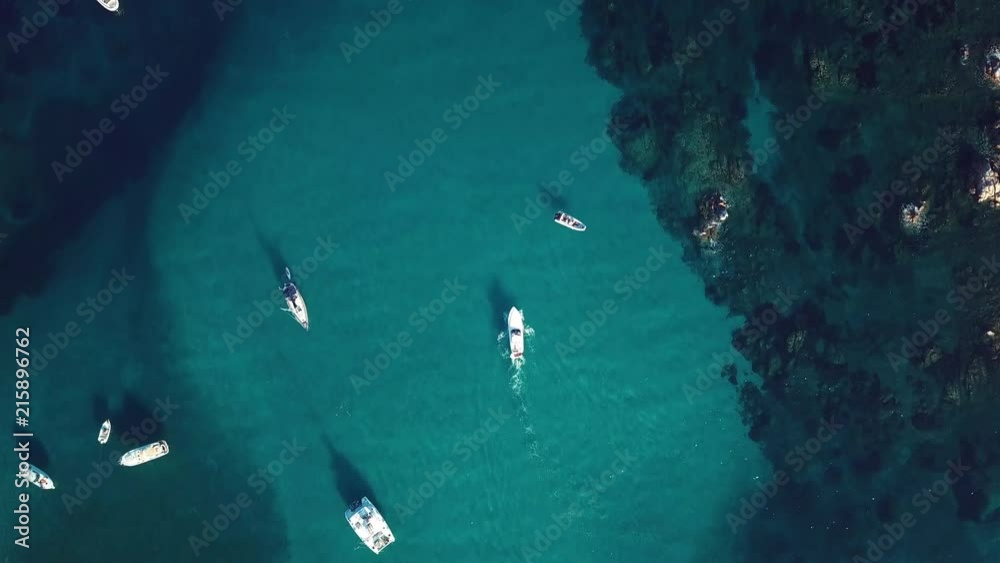 View from above, aerial view of a yacht sailing on a transparent and turquoise sea. Emerald Coast, Sardinia, Italy. View from above, aerial view of a yacht sailing on a transparent and turquoise sea. Emerald Coast, Sardinia, Italy.