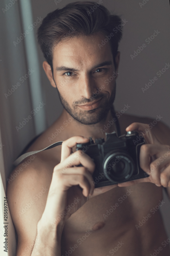 Sexy nude man, an amateur photographer, holding an slr camera foto de Stock  | Adobe Stock