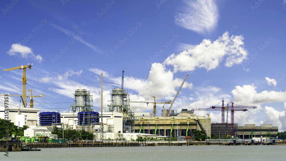 Industrial power plant with blue sky. Industrial construction cranes and building
