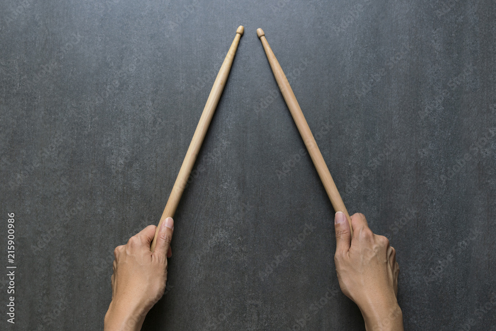 hand holding drum stick on black table background, music practice concept hand holding drum stick on black table background, music practice concept