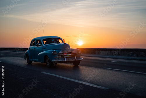 Blue Vintage American Car in Havana Cuba during Sunset on Malecon Highway with Sea Wall next to the Ocean.