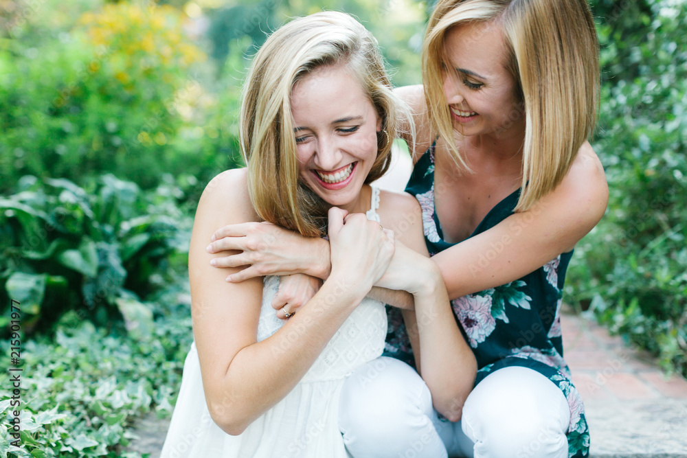 Two young girls laughing and hugging Two young girls laughing and hugging