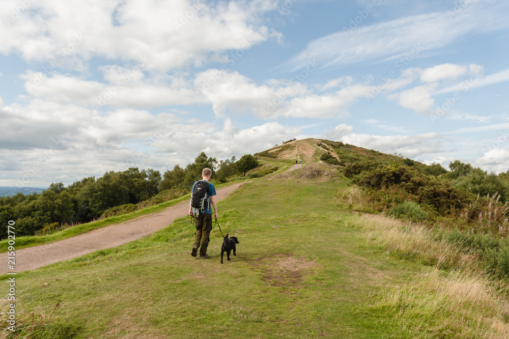Man walking his dog across the Malvern Hills Man walking his dog across the Malvern Hills