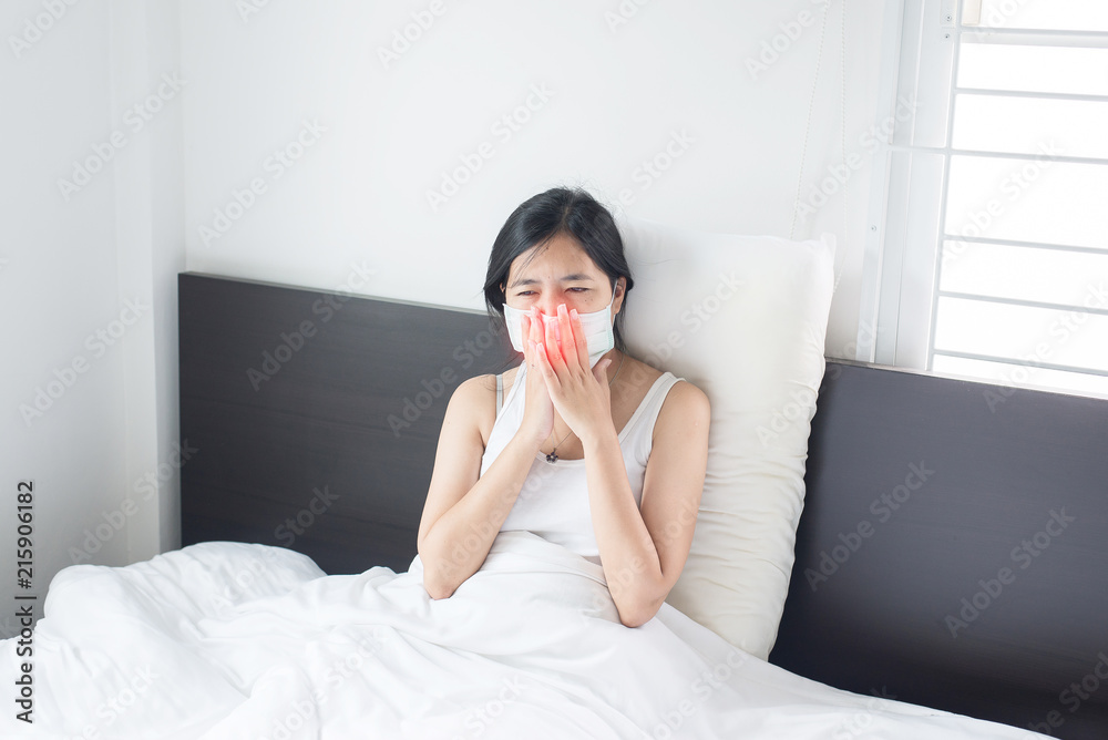 Young asian woman coughing and sitting on her bed,Concept of health Young asian woman coughing and sitting on her bed,Concept of health
