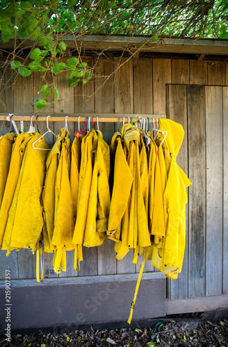 Collection of yellow raincoats hanging outside
