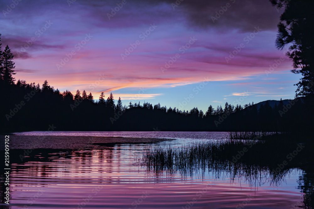 California sunset over lake surrounded by forest