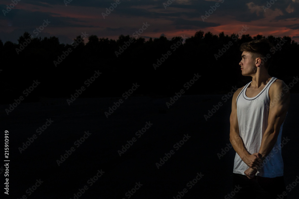 Fototapeta premium Young adult male outside at sunset