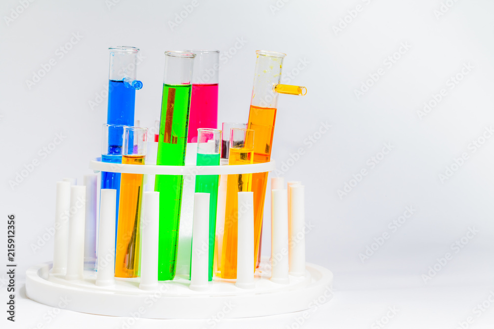 Experiments in mixing chemical substances into glass tubes with a microscope in a science lab with a white background.. Experiments in mixing chemical substances into glass tubes with a microscope in a science lab with a white background..
