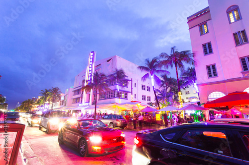 Ocean Drive scene at sunset with lights, palm trees, cars and people having fun, Miami beach. Art Deco style hotels and restaurants at sunset on Ocean Drive, world famous destination for its nightlife