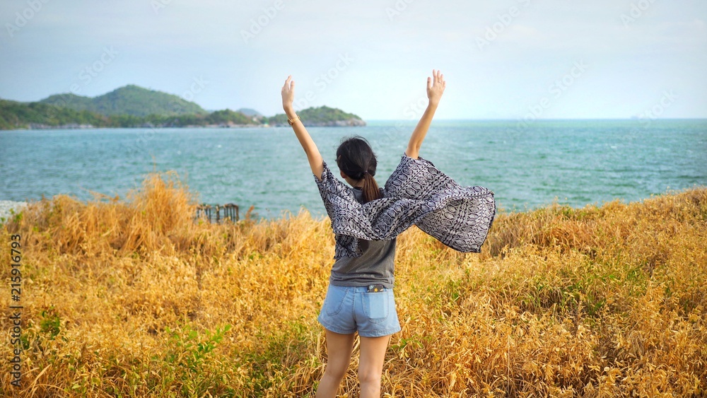 Portrait of young woman relaxing with meadow, sea, mountain, blue sky and cloud at Koh Sichang in Thailand, Space for text in template, Travel concept, Many tourists visit here, View for seascape Portrait of young woman relaxing with meadow, sea, mountain, blue sky and cloud at Koh Sichang in Thailand, Space for text in template, Travel concept, Many tourists visit here, View for seascape