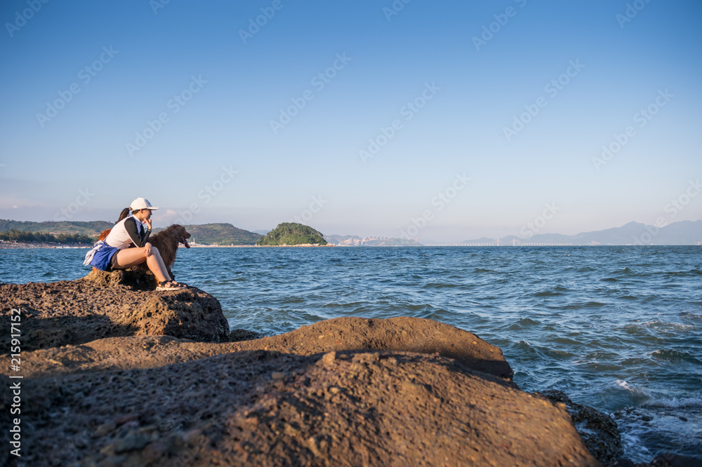 Golden retriever and Girl on the rocks by the sea Golden retriever and Girl on the rocks by the sea