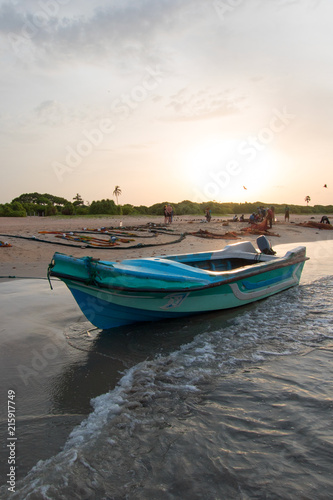 Sunset view of small fishing boat on Nilaveli beach in Trincomalee Sri Lanka Asia