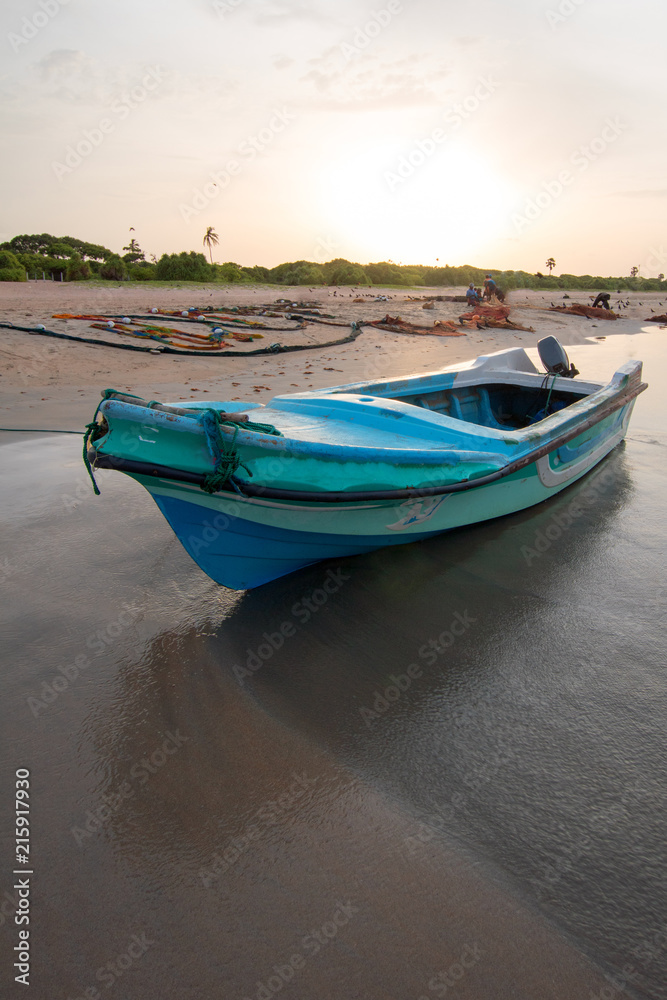 Small fishing boat at sunset on Nilaveli beach in Trincomalee Sri Lanka Asia