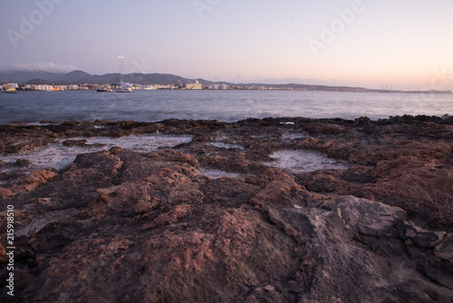 Ibiza sunset with rocks and basalt salt water over the Mediterranean coast 