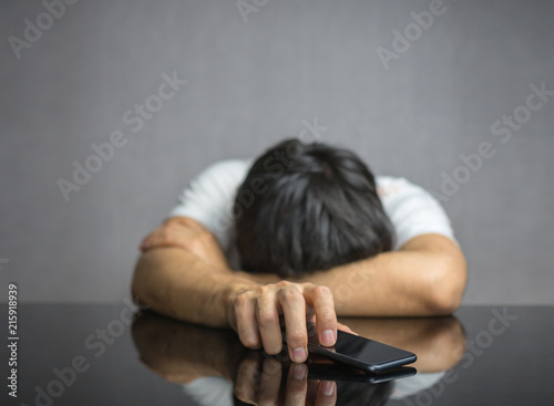Man waiting for a phone call on table, face down