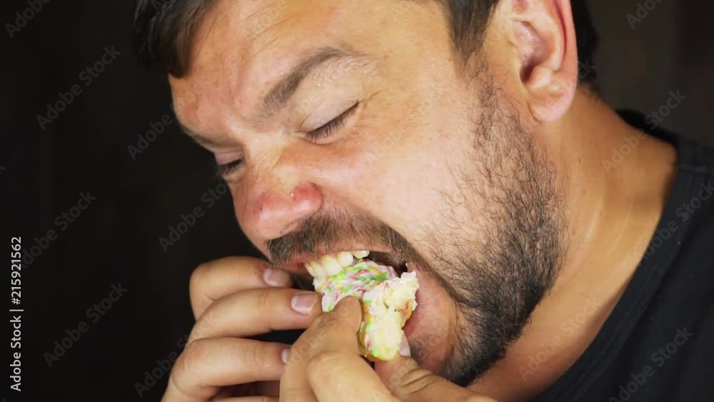 Portrait of a young hungry man eating a donut Portrait of a young hungry man eating a donut
