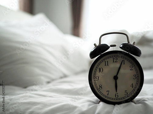alarm clock on the bed in bedroom on morning