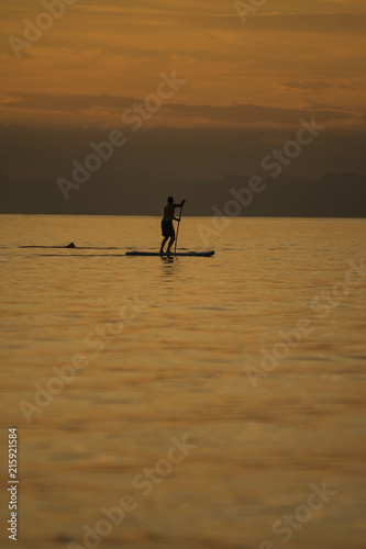 Men on sup in sunset