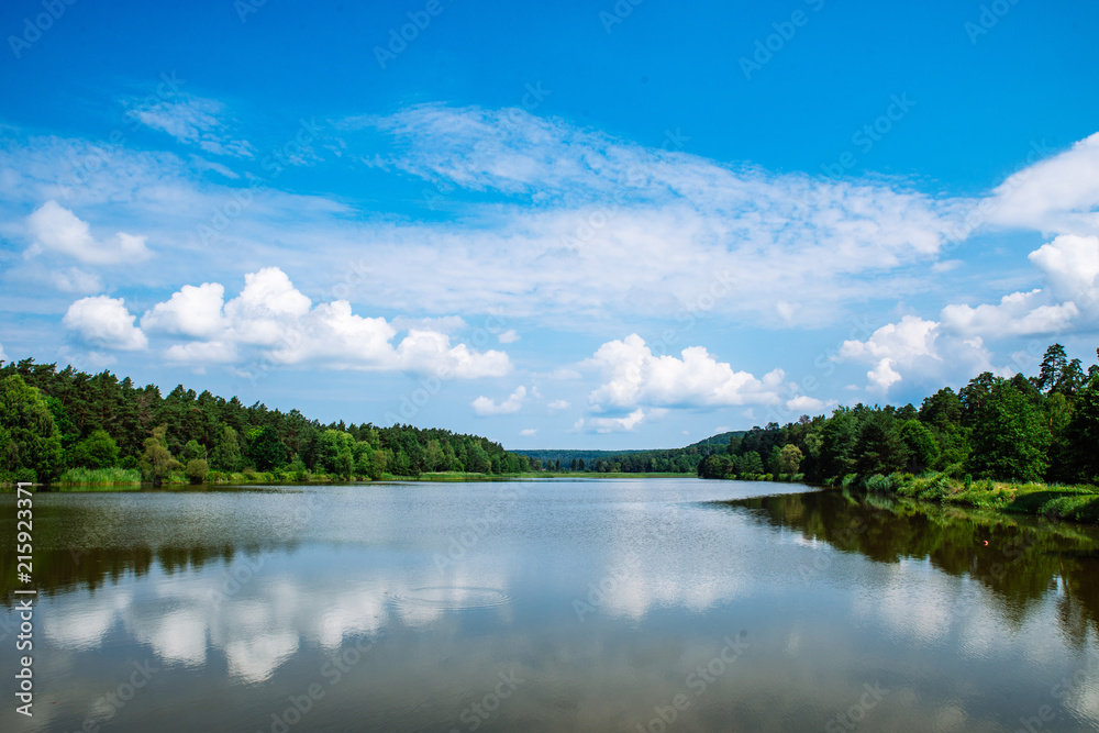 landscape view of lake in sunny summer day. sky reflection in water