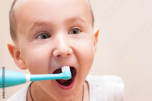 baby and electric toothbrush photo